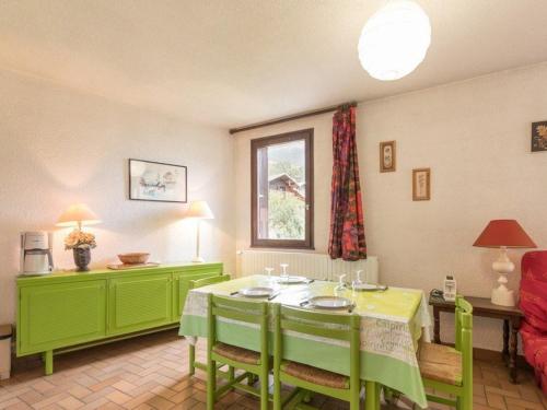 une salle à manger avec une table et des chaises vertes dans l'établissement Charmant 2 pièces à Serre-Chevalier, balcon, parking, 5 pers. - Animaux non admis - FR-1-330E-2, à Saint-Chaffrey