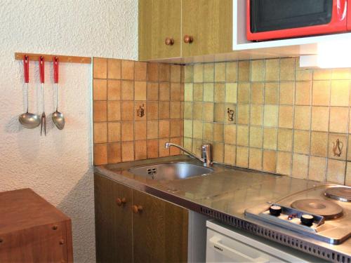 - une cuisine avec un évier et un comptoir avec des ustensiles dans l'établissement Appartement Vars, 1 pièce, 4 personnes - FR-1-330B-85, à Vars