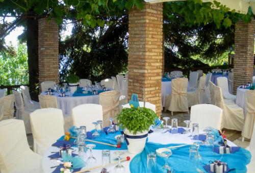 a table set up for a wedding with blue tables and white chairs at Pigi Tarlampa Hotel in Ano Trikala