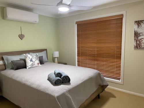 1 dormitorio con 1 cama con toallas en SPECTACULAR WATERFRONT Canal Home, BRIBIE ISLAND, en Banksia Beach
