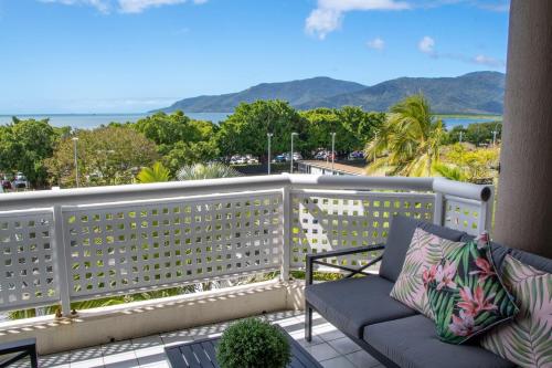 a bench on a balcony with a view of the ocean at Cairns Luxury Waterview Apartment in Cairns