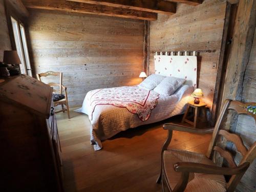 a bedroom with a bed and a wooden wall at Chalet Arêches-Beaufort, 4 pièces, 6 personnes - FR-1-342-158 in Beaufort