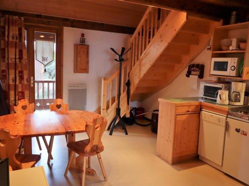 une cuisine avec une table en bois et un escalier en bois dans l'établissement Duplex cosy 33m² à Arêches-Beaufort, pour 4 pers., pied des pistes, animaux admis, parking - FR-1-342-157, à Beaufort