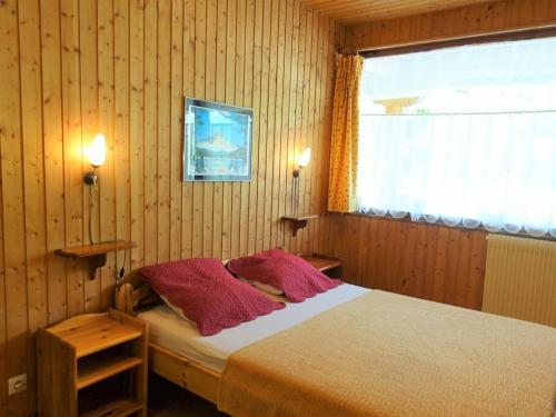 um quarto com uma cama com duas almofadas e uma janela em Appartement Arêches-Beaufort, 3 pièces, 6 personnes - FR-1-342-195 em Arêches