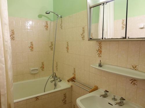 Un baño con lavabo, bañera y espejo. en Appartement chaleureux 6 pers. au pied des pistes et des randonnées, classé 2 étoiles - FR-1-342-195, en Arêches