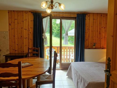 a dining room with a table and a bed and a window at Appartement calme 4 pers, pied des pistes avec parking - FR-1-342-160 in Arêches