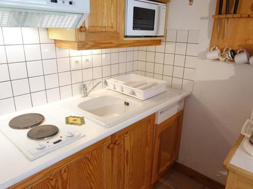 un comptoir de cuisine avec un évier et un micro-ondes dans l'établissement Appartement cosy 4 pers. au pied des pistes avec terrasse - Arêches-Beaufort - FR-1-342-181, à Beaufort