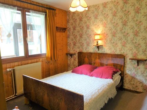a bedroom with a bed with a pink pillow at Appartement Arêches-Beaufort, 2 pièces, 4 personnes - FR-1-342-200 in Arêches-Beaufort