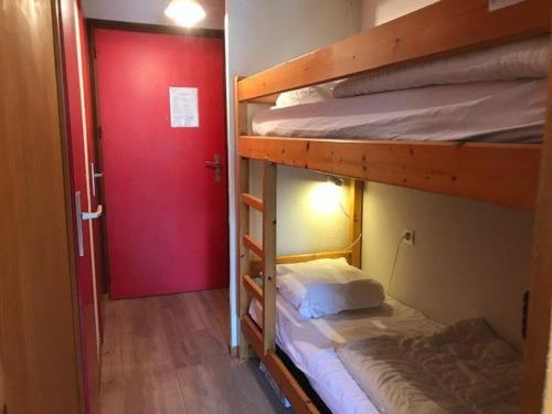 Cette chambre comprend 2 lits superposés et une porte rouge. dans l'établissement Appartement Arêches-Beaufort, 2 pièces, 4 personnes - FR-1-342-173, à Arêches