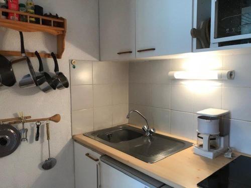 une cuisine avec un évier et un plan de travail dans l'établissement Appartement cosy pour 4, au cœur du village, proche des pistes et avec piscine estivale - FR-1-342-173, à Arêches
