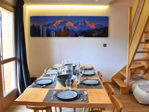 une longue table en bois avec des verres et des assiettes dans l'établissement Duplex spacieux 10 pers, proche pistes, parking, internet - FR-1-180-384, à Les Allues