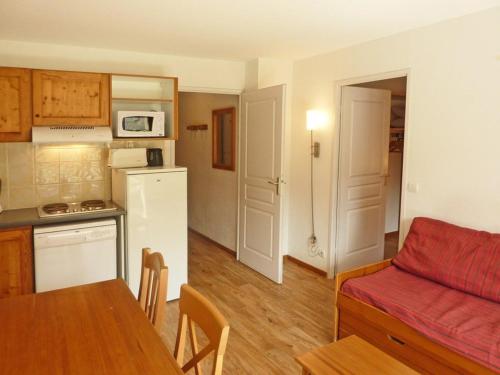 Il dispose d'une cuisine et d'un salon avec un canapé et une table. dans l'établissement Appartement Cosy 4 Pers, Piscine, Jacuzzi, Balcon Sud-Ouest, 50m des Pistes – Les Orres - FR-1-322-380, aux Orres