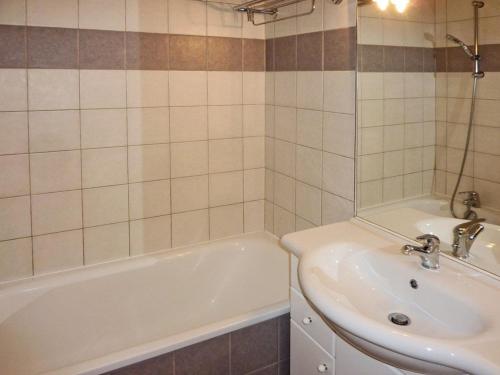 une salle de bain avec une baignoire blanche et un lavabo dans l'établissement Appartement Cosy 4 Pers, Piscine, Jacuzzi, Balcon Sud-Ouest, 50m des Pistes – Les Orres - FR-1-322-380, aux Orres