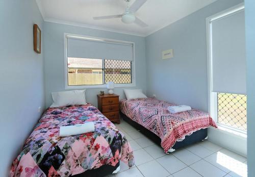 a bedroom with two beds and a window at 46 Holland Street Bargara in Bargara