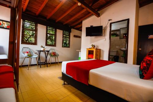 a bedroom with a bed and a table and chairs at Hostal The Garden Lleras 10 in Medellín