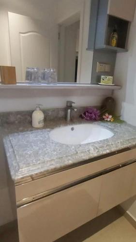 a bathroom counter with a sink and a mirror at FENUA ORA in Mahina