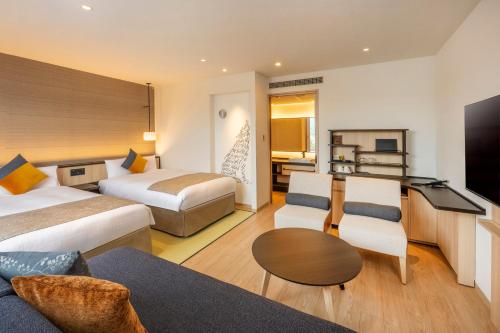 pokój hotelowy z 2 łóżkami i kanapą w obiekcie KAMENOI HOTEL Ome w mieście Ome