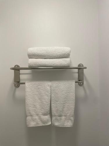un grupo de toallas colgando en un estante en Anavada Inn & Suites - Grande Prairie, en Grande Prairie