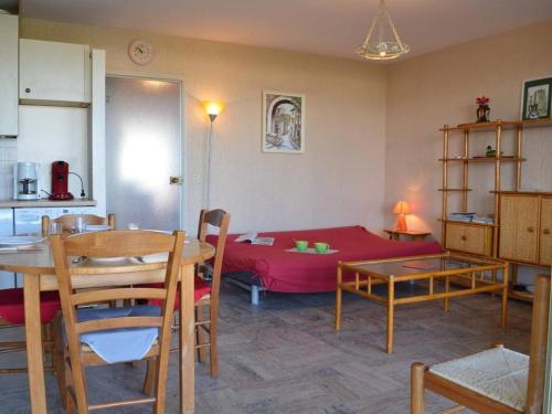 ein Wohnzimmer mit einem roten Bett und einem Tisch in der Unterkunft Appartement Le Lavandou, 3 pièces, 5 personnes - FR-1-251-316 in Le Lavandou