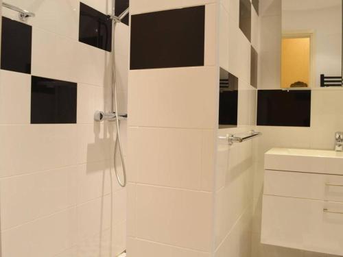ein weißes Bad mit einer Dusche und einem Waschbecken in der Unterkunft Appartement Le Lavandou, 3 pièces, 5 personnes - FR-1-251-316 in Le Lavandou