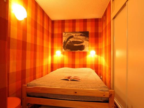 Cette petite chambre comprend un petit lit avec deux lumières. dans l'établissement Location idéale, 4 pers à Serre-Chevalier, proche pistes, balcon, TV, coin nuit et casier à ski - FR-1-330E-86, à Saint-Chaffrey