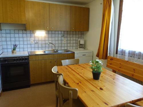 - une cuisine avec une table en bois, des chaises et un évier dans l'établissement Appartement 5 pers. 2 étoiles au pied des pistes, Arêches-Beaufort, 36m², parking, proche randonnée - FR-1-342-155, à Arêches