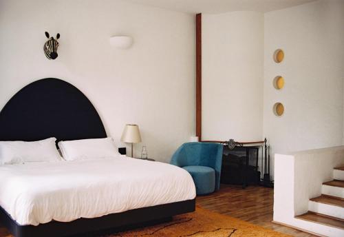 ein Schlafzimmer mit einem Bett und einem blauen Stuhl in der Unterkunft Casa Pani in Mexiko-Stadt