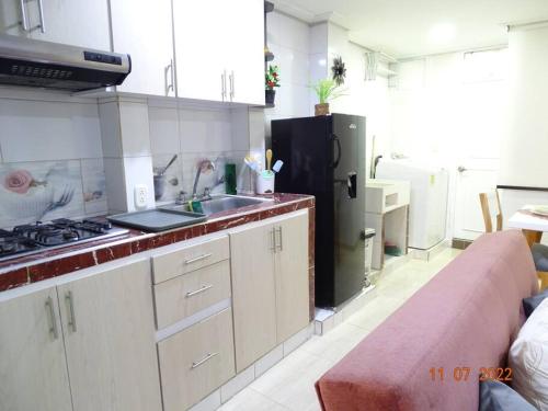 a kitchen with a refrigerator and a sink and a couch at Acogedor apartamento en Fusagasugá in Fusagasuga