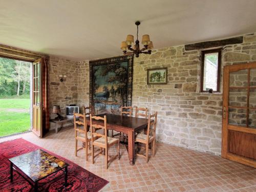 une salle à manger avec une table et un mur de briques dans l'établissement Apartment in Bénodet near Sandy Beaches, à Bénodet