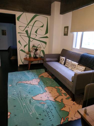 sala de estar con sofá y alfombra de mapa en Wanderlust en San Miguel de Tucumán