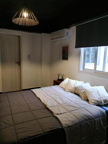 Un dormitorio con una cama grande y una ventana en Wanderlust en San Miguel de Tucumán