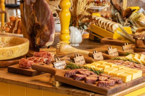 a table with cheese and meats and other foods at Hotel Valle Dincanto in Gramado