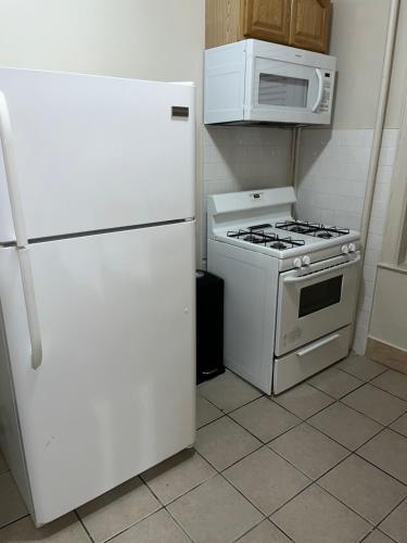 a kitchen with a white refrigerator and a microwave at The Jersey City Relief in Jersey City