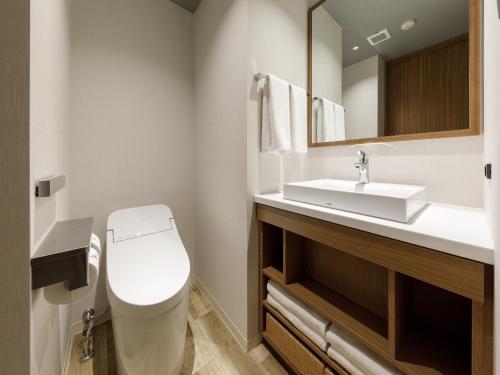 a bathroom with a white toilet and a sink at Nishitetsu Hotel Croom Hakata Gion Kushida Shrine in Fukuoka