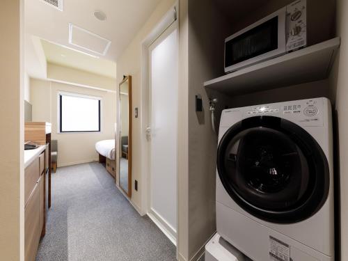 a washer and dryer in a room at Nishitetsu Hotel Croom Hakata Gion Kushida Shrine in Fukuoka