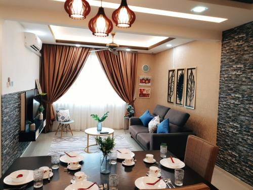 uma sala de estar com uma mesa e um sofá em KLIA EHSAN Residence Sepang Nilai Greenery 8 PAX Air-Con Suite em Sepang