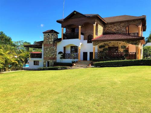 una grande casa con un prato davanti di Villa Amila By Hospedify Hermosa Villa para 20 personas y a 4 minutos del Río de Jarabacoa a Jarabacoa