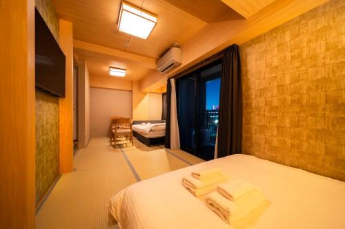 a bedroom with a bed with three towels on it at WELLSTAY Shinsekai Wakyo in Osaka