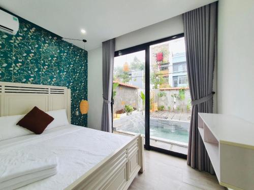 a bedroom with a bed and a large window at Villa 68 4BR FREE PICK-UP AIRPORT & BILLIARDS CLOSE TO MY KHE BEACH in Da Nang