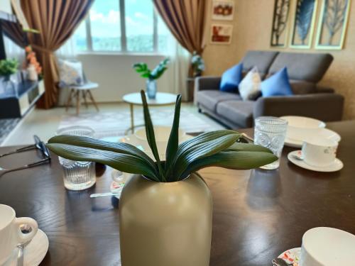 um vaso com uma planta sobre uma mesa numa sala de estar em KLIA EHSAN Residence Sepang Nilai Greenery 8 PAX Air-Con Suite em Sepang