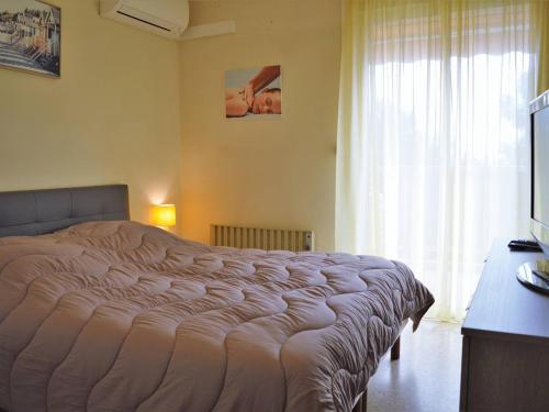 um quarto com uma cama grande e uma janela em Appartement Le Lavandou, 2 pièces, 4 personnes - FR-1-251-295 em Le Lavandou