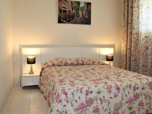 a bedroom with a bed with a floral bedspread at Appartement Villeneuve-Loubet, 2 pièces, 4 personnes - FR-1-252A-9 in Villeneuve-Loubet