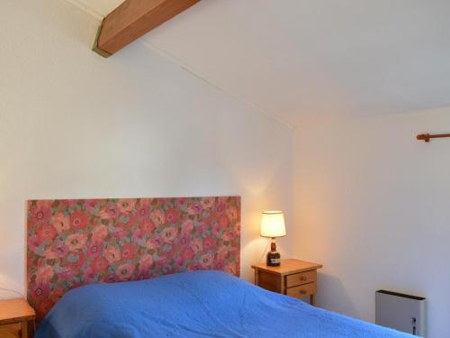 een slaapkamer met een blauw bed met een bloemrijk hoofdeinde bij Appartement Saint-Aygulf, 2 pièces, 4 personnes - FR-1-226A-14 in Saint-Aygulf
