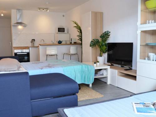 un salon avec un lit et une cuisine dans l'établissement Studio rénové avec terrasse, aperçu mer et parking privatif au Lavandou, 3 couchages - FR-1-251-303, au Lavandou