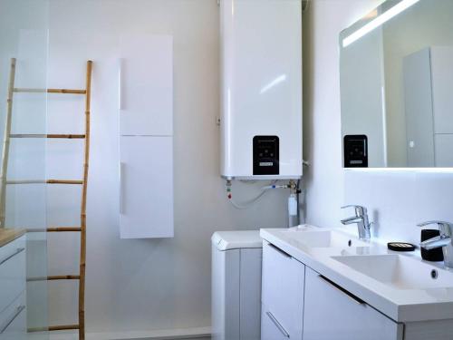 une salle de bain blanche avec un lavabo et un miroir dans l'établissement Studio rénové avec terrasse, aperçu mer et parking privatif au Lavandou, 3 couchages - FR-1-251-303, au Lavandou