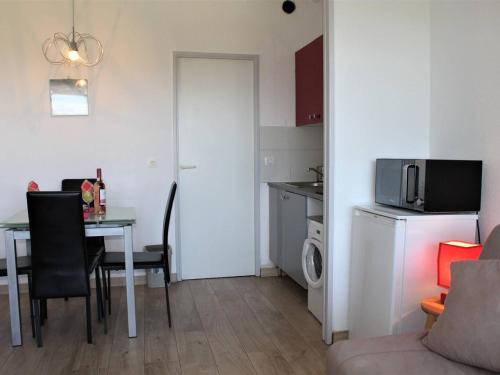 Ce petit appartement comprend une table et une cuisine. dans l'établissement Studio Moderne avec Terrasse, Plage à 150m, Clim, Jardin et Tennis - FR-1-252A-5, à Villeneuve-Loubet