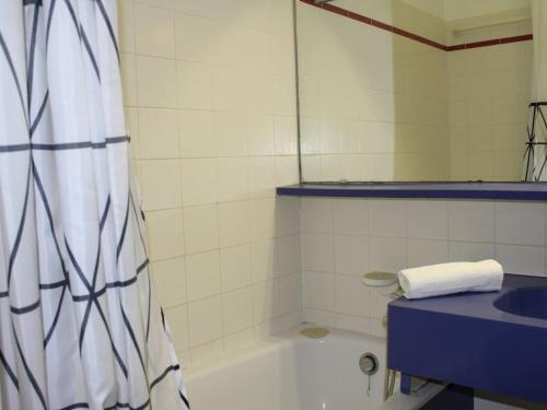 une salle de bain avec une baignoire et un lavabo dans l'établissement Studio Moderne avec Terrasse, Plage à 150m, Clim, Jardin et Tennis - FR-1-252A-5, à Villeneuve-Loubet