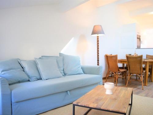 un salon avec un canapé bleu et une table dans l'établissement Charmant 2P rénové, cœur médiéval, 4 couchages - Bormes-les-Mimosas - FR-1-251-311, à Bormes-les-Mimosas