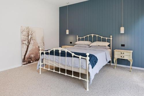 a bedroom with a white bed and a blue wall at Endless Somers in Somers