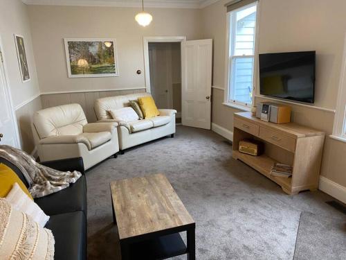a living room with two couches and a tv at Glendale Cottage in Daylesford
